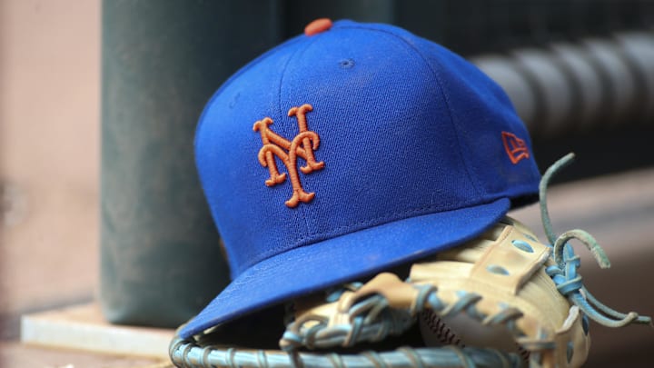 Jul 13, 2022; Atlanta, Georgia, USA; A detailed view of a New York Mets hat and glove in the dugout against the Atlanta Braves in the eighth inning at Truist Park. Mandatory Credit: Brett Davis-Imagn Images