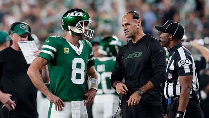 Aaron Rodgers speaks with Robert Saleh on the sideline. 