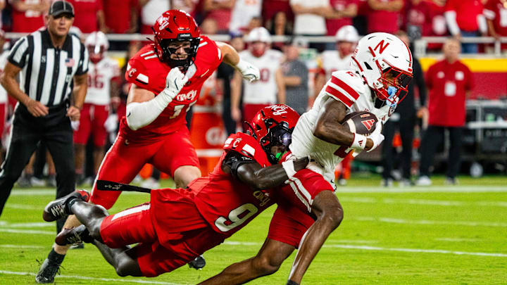 Aug 28, 2025; Kansas City, Missouri, USA; Nebraska Cornhuskers wide receiver Jacory Barney Jr. (2) is tackled by Cincinnati Bearcats defensive back Jiquan Sanks (9) during the first quarter at GEHA Field at Arrowhead Stadium. Mandatory Credit: Dylan Widger-Imagn Images