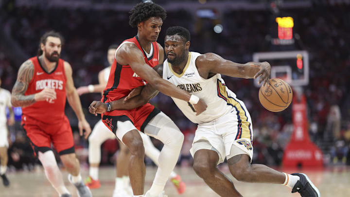 Mar 8, 2025; Houston, Texas, USA;  New Orleans Pelicans forward Zion Williamson (1) attempts to control the ball as Houston Rockets forward Amen Thompson (1) defends during the second quarter at Toyota Center. Mandatory Credit: Troy Taormina-Imagn Images