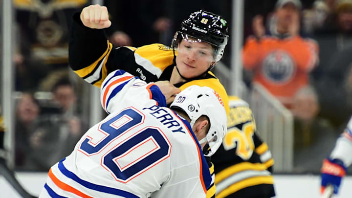 Jan 7, 2025; Boston, Massachusetts, USA;  Boston Bruins center Trent Frederic (11) fights with Edmonton Oilers right wing Corey Perry (90) during the second period at TD Garden. Mandatory Credit: Bob DeChiara-Imagn Images