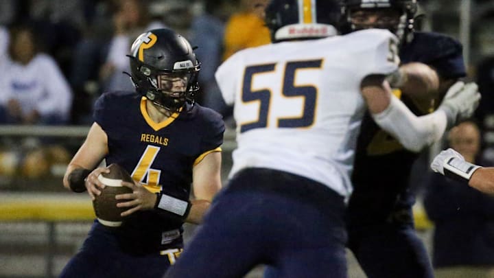 Regina’s Kyle Tracy (4) looks to pass against Cascade Friday, Sept. 27, 2024 in Iowa City, Iowa.