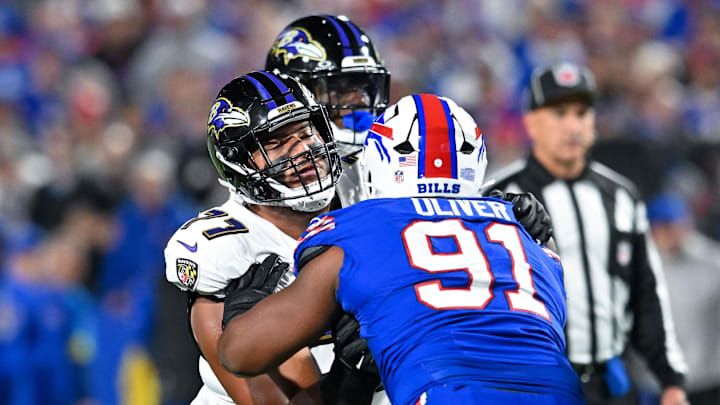 Sep 7, 2025; Orchard Park, New York, USA; Baltimore Ravens guard Daniel Faalele (77) blocks Buffalo Bills defensive tackle Ed Oliver (91) in the first quarter at Highmark Stadium