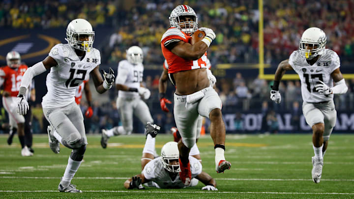 Ohio State Buckeyes running back Ezekiel Elliott (15) scores a 33-yard touchdown between Oregon Ducks defensive back Chris Seisay (12) and defensive back Troy Hill (13) during the first quarter of the College Football Playoff National Championship at AT&T Stadium in Arlington, Texas on Jan. 12, 2015.