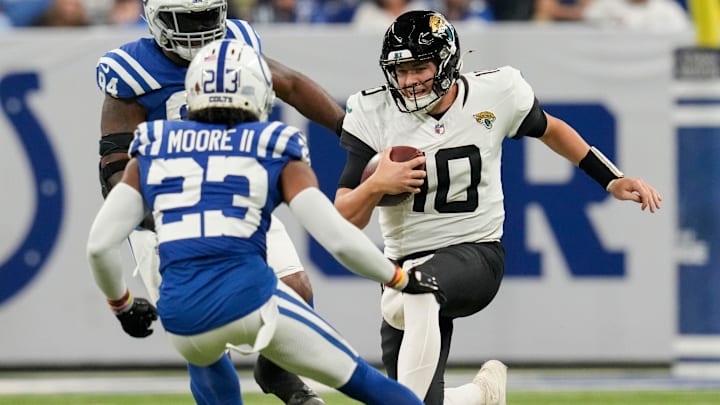 Jacksonville Jaguars quarterback Mac Jones (10) slides as Indianapolis Colts cornerback Kenny Moore II (23) moves in to tackle Sunday, Jan. 5, 2025, during a game against the Jacksonville Jaguars at Lucas Oil Stadium in Indianapolis.