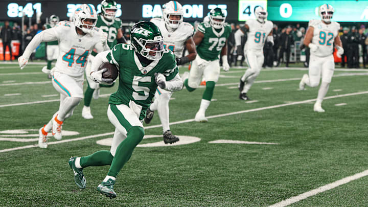 Jan 5, 2025; East Rutherford, New Jersey, USA; New York Jets wide receiver Garrett Wilson (5) gains yards after catch as Miami Dolphins linebacker Chop Robinson (44) pursues during the first half at MetLife Stadium. Mandatory Credit: Vincent Carchietta-Imagn Images Jan 5, 2025; East Rutherford, New Jersey, USA; New York Jets wide receiver Garrett Wilson (5) gains yards after catch as Miami Dolphins linebacker Chop Robinson (44) pursues during the first half at MetLife Stadium. Mandatory Credit: Vincent Carchietta-Imagn Images