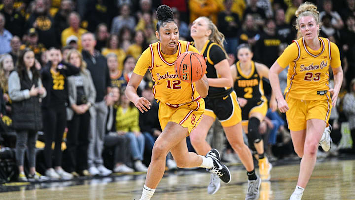 Feb 2, 2025; Iowa City, Iowa, USA; USC Trojans guard JuJu Watkins (12) drives the ball late during the second quarter against the Iowa Hawkeyes as guard Avery Howell (23) looks on at Carver-Hawkeye Arena. Mandatory Credit: Jeffrey Becker-Imagn Images