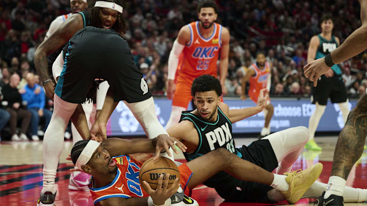 Nov 30, 2025; Portland, Oregon, USA; Oklahoma City Thunder guard Shai Gilgeous-Alexander (2) scrambles to control the ball during the second half against Portland Trail Blazers guard Shaedon Sharpe (17) and forward Toumani Camara (33) at Moda Center. Mandatory Credit: Troy Wayrynen-Imagn Images