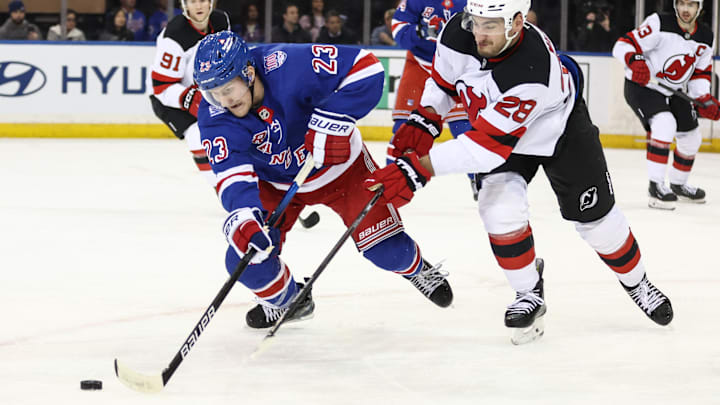 Mar 18, 2026; New York, New York, USA;  New York Rangers defenseman Adam Fox (23) and New Jersey Devils right wing Timo Meier (28) battle for control of the puck in the third period at Madison Square Garden. Mandatory Credit: Wendell Cruz-Imagn Images