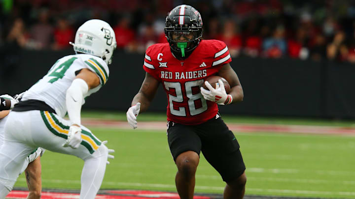Oct 19, 2024; Lubbock, Texas, USA;  Texas Tech Red Raiders running back Tahj Brooks (28) runs the ball against Baylor Bears safety Corey Gordon Jr. (4) in the second half at Jones AT&T Stadium and Cody Campbell Field. Mandatory Credit: Michael C. Johnson-Imagn Images