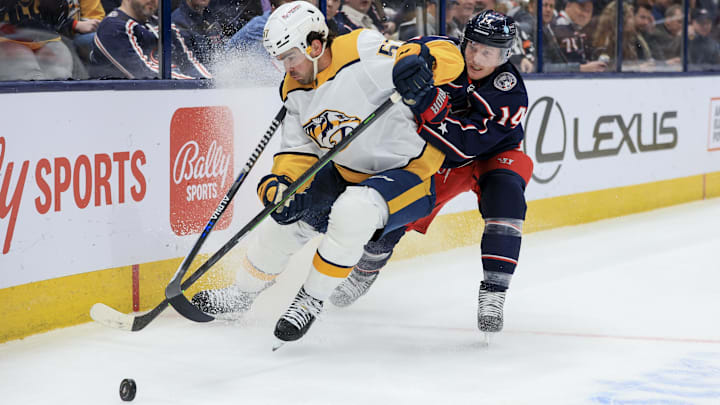Oct 20, 2022; Columbus, Ohio, USA;  Nashville Predators defenseman Dante Fabbro (57) skates with the puck against Columbus Blue Jackets left wing Gustav Nyquist (14) in the second period at Nationwide Arena. Mandatory Credit: Aaron Doster-Imagn Images