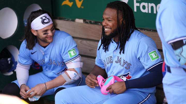 Jun 8, 2024; Oakland, California, USA; Toronto Blue Jays first baseman Vladimir Guerrero Jr. (27) sits next to shortstop Bo Bichette (11) before the start of the game against the Oakland Athletics at Oakland-Alameda County Coliseum. Mandatory Credit: Cary Edmondson-Imagn Images