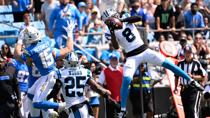 Sep 15, 2024; Charlotte, North Carolina, USA; Carolina Panthers cornerback Jaycee Horn (8) intercepts a ball intended for Los Angeles Chargers wide receiver Ladd McConkey (15) as safety Xavier Woods (25) looks on in the first quarter at Bank of America Stadium. Mandatory Credit: Bob Donnan-Imagn Images