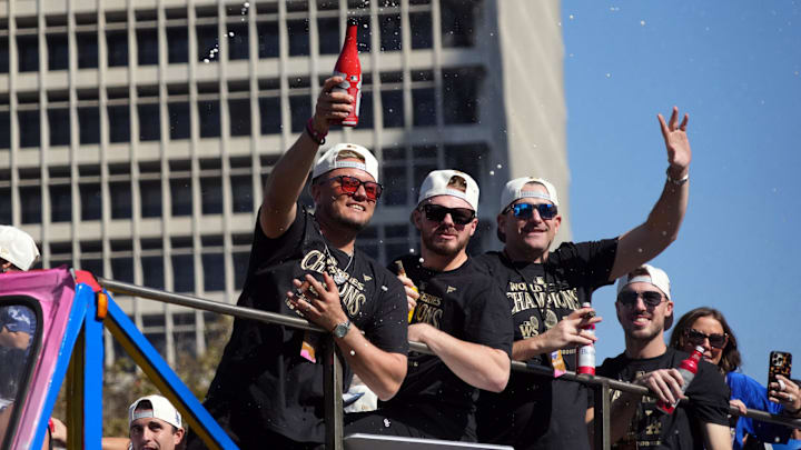 Nov 1, 2024; Los Angeles, CA, USA; Los Angeles Dodgers shortstop Miguel Rojas (left) and second baseman Gavin Lux (center) celebrate on the bus during the 2024 World Series championship parade near Los Angeles City Hall. Mandatory Credit: Kirby Lee-Imagn Images