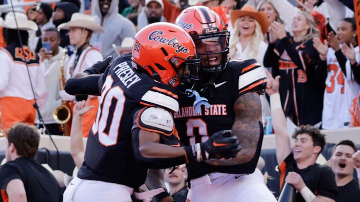 Oklahoma State's Brennan Presley and Ollie Gordon II celebrate after a touchdown during an NCAA football game on Saturday, Nov. 23, 2024, in Stillwater, Okla.