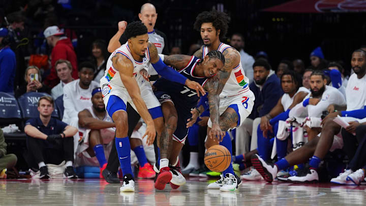 Nov 24, 2024; Philadelphia, Pennsylvania, USA; Los Angeles Clippers guard Kevin Porter Jr (77) collides with Philadelphia 76ers forward KJ Martin (1) and guard Kelly Oubre Jr (9) in the fourth quarter at Wells Fargo Center. Mandatory Credit: Kyle Ross-Imagn Images