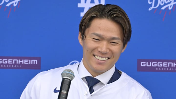 Dec 27, 2023; Los Angeles, CA, USA; Los Angeles Dodgers starting pitcher Yoshinobu Yamamoto (18) answers questions from media during an introductory press conference at Dodgers Stadium. Mandatory Credit: Jayne Kamin-Oncea-Imagn Images