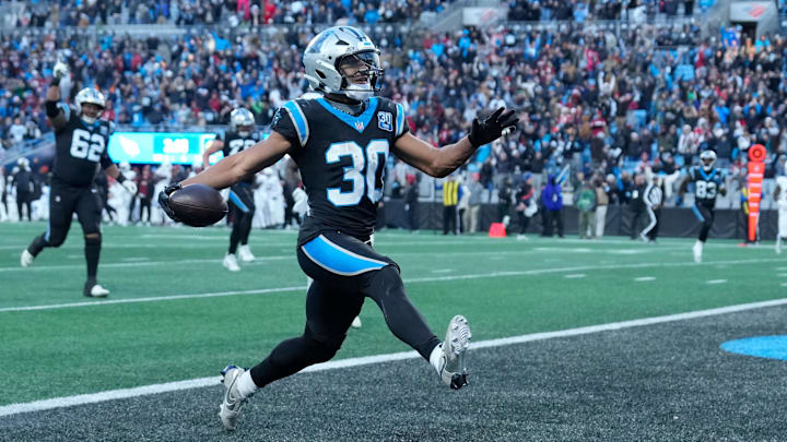 Dec 22, 2024; Charlotte, North Carolina, USA; Carolina Panthers running back Chuba Hubbard (30) scores in overtime to win the gqme at Bank of America Stadium. Mandatory Credit: Bob Donnan-Imagn Images
