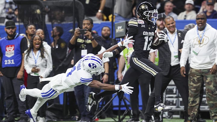 Dec 28, 2024; San Antonio, TX, USA; Colorado Buffaloes wide receiver Travis Hunter (12) runs with the ball as Brigham Young Cougars cornerback Mory Bamba (4) attempts to make a tackle during the second quarter at Alamodome. Mandatory Credit: Troy Taormina-Imagn Images Dec 28, 2024; San Antonio, TX, USA; Colorado Buffaloes wide receiver Travis Hunter (12) runs with the ball as Brigham Young Cougars cornerback Mory Bamba (4) attempts to make a tackle during the second quarter at Alamodome. Mandatory Credit: Troy Taormina-Imagn Images