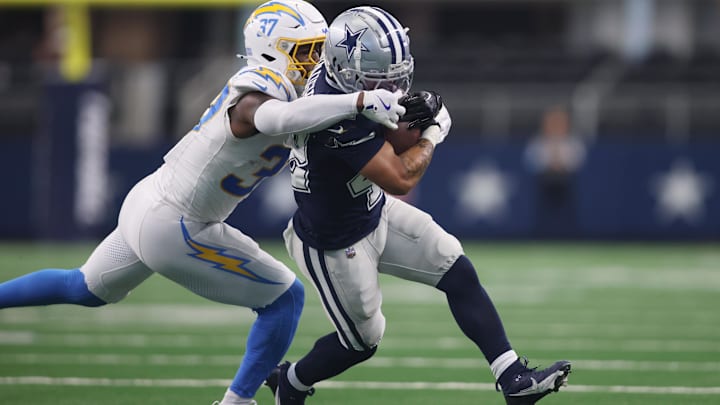 Los Angeles Chargers safety Thomas Harper grabs the facemask of Dallas Cowboys running back Deuce Vaughn.