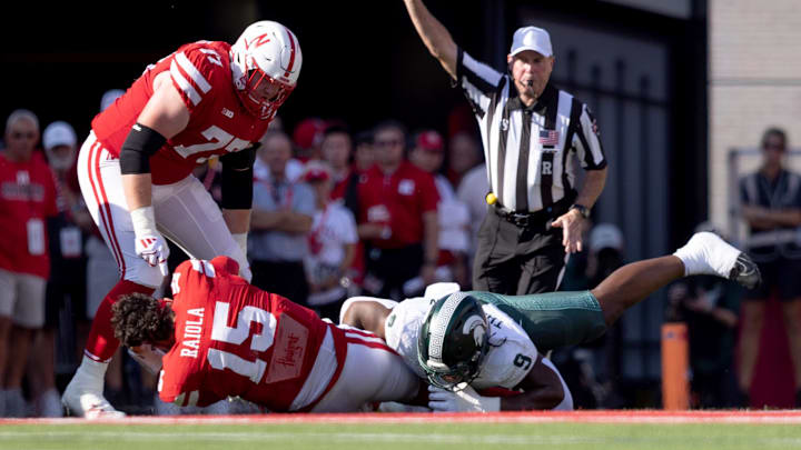 Oct 4, 2025; Lincoln, Nebraska, USA; Nebraska Cornhuskers quarterback Dylan Raiola (15) loses his helmet as he is sacked by Michigan State Spartans defensive lineman Jalen Thompson (9) at Memorial Stadium. Mandatory Credit: Kylie Graham-Imagn Images Oct 4, 2025; Lincoln, Nebraska, USA; Nebraska Cornhuskers quarterback Dylan Raiola (15) loses his helmet as he is sacked by Michigan State Spartans defensive lineman Jalen Thompson (9) at Memorial Stadium. Mandatory Credit: Kylie Graham-Imagn Images
