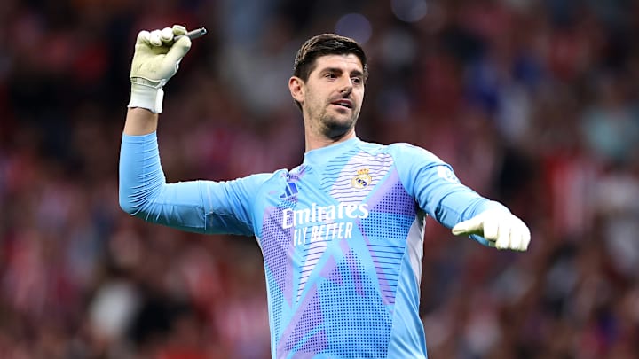 Thibaut Courtois sacando los mecheros que le tiraron los aficionados adversarios a su portería