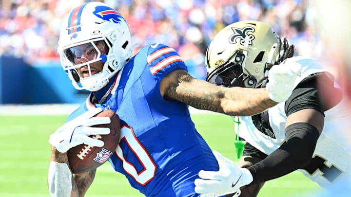 Buffalo Bills wide receiver Keon Coleman (0) runs for a gain past New Orleans Saints cornerback Kool-Aid McKinstry (4) during the first quarter at Highmark Stadium.