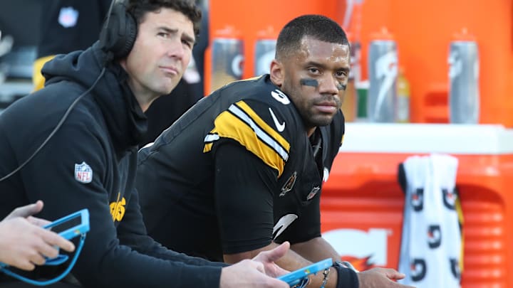 Dec 8, 2024; Pittsburgh, Pennsylvania, USA;  Pittsburgh Steelers quarterbacks coach Tom Arth (left) and quarterback Russell Wilson (3) look on from the bench against the cle/ during the third quarter at Acrisure Stadium. Mandatory Credit: Charles LeClaire-Imagn Images