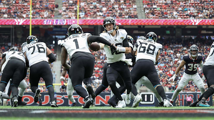 Sep 29, 2024; Houston, Texas, USA; Jacksonville Jaguars quarterback Trevor Lawrence (16) hands off to running back Travis Etienne Jr. (1) during the fourth quarter against the Houston Texans at NRG Stadium. Mandatory Credit: Troy Taormina-Imagn Images