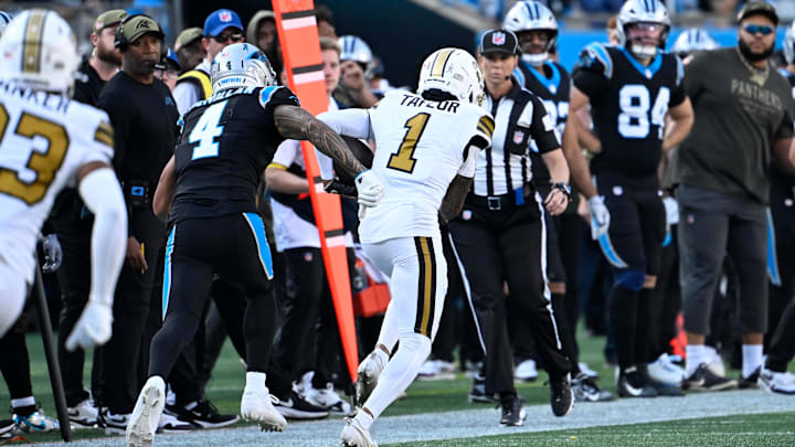 Nov 9, 2025; Charlotte, North Carolina, USA; New Orleans Saints cornerback Alontae Taylor (1) intercepts a pass as Carolina Panthers wide receiver Tetairoa McMillan (4) defends in the fourth quarter at Bank of America Stadium. Mandatory Credit: Bob Donnan-Imagn Images