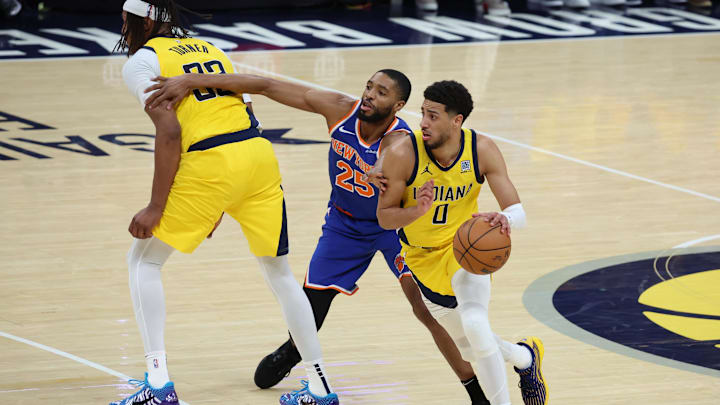 May 25, 2025; Indianapolis, Indiana, USA; Indiana Pacers guard Tyrese Haliburton (0) dribbles past New York Knicks forward Mikal Bridges (25) during the fourth quarter of game three of the eastern conference finals for the 2025 NBA Playoffs at Gainbridge Fieldhouse. Mandatory Credit: Trevor Ruszkowski-Imagn Images