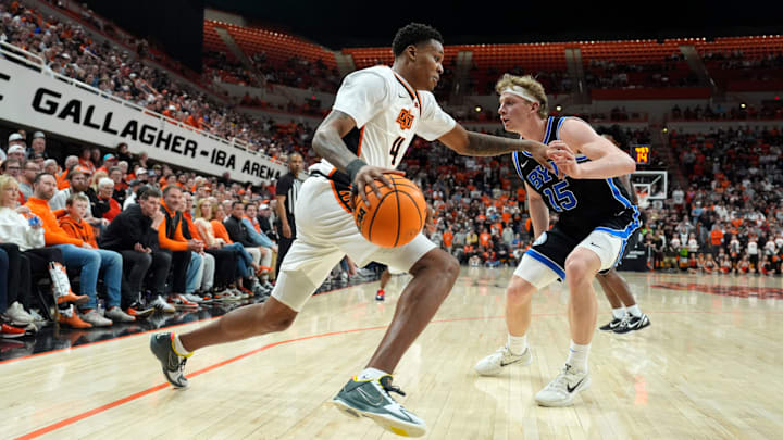 Oklahoma State Cowboys guard Christian Coleman (4) dribbles beside BYU Cougars guard Richie Saunders (15) during a BIG 12 men's college basketball game between the Oklahoma State Cowboys (OSU) and the BYU Cougars at Gallagher-Iba Arena in Stillwater, Okla., Wednesday, Feb. 4, 2026.