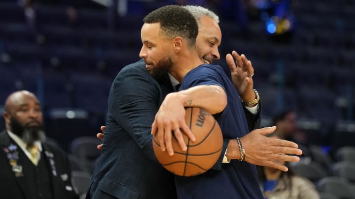 Charlotte color commentator Dell Curry greets his son, Golden State guard Steph Curry, before a Hornets-Warriors game at Chase Center.
