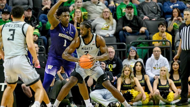 Jan 21, 2025; Eugene, Oregon, USA; Oregon Ducks forward Supreme Cook (7) drives against Washington Huskies forward Great Osobor (1) during the second half at Matthew Knight Arena. Mandatory Credit: Craig Strobeck-Imagn Images