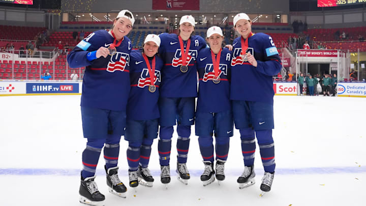 Former Eagles Cayla Barnes, Megan Keller, and Alex Carpenter (middle three) are joined by Hilary Knight (left) and Lee Stecklein (right) after Team USA wins 2025 IIFH Women's  World Championship.