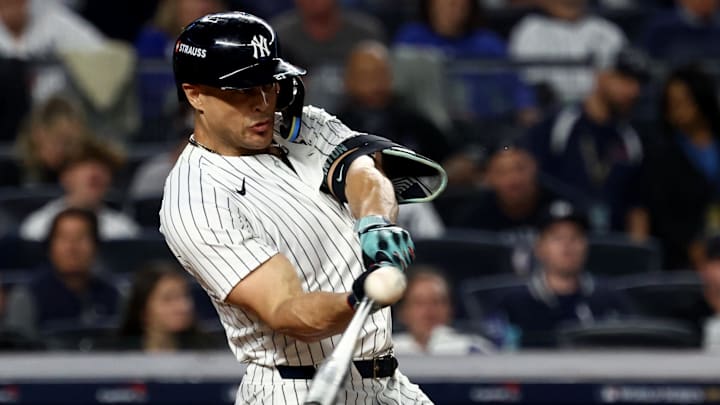 Oct 30, 2024; New York, New York, USA; New York Yankees designated hitter Giancarlo Stanton (27) hits a home run during the third inning against the Los Angeles Dodgers in game five of the 2024 MLB World Series at Yankee Stadium.