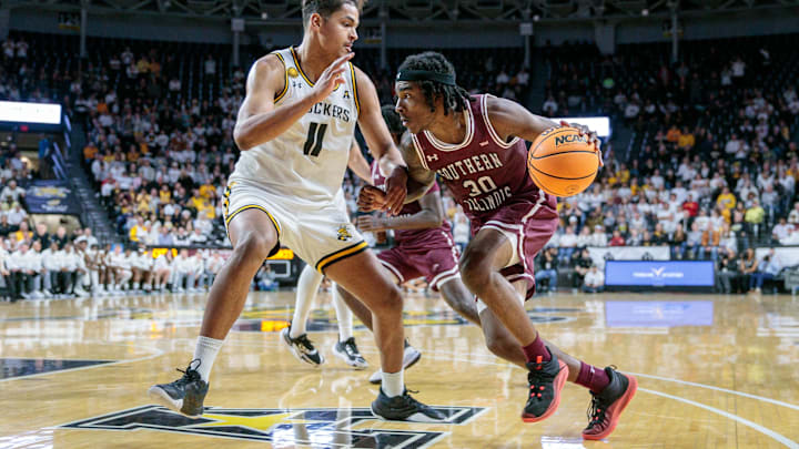 Southern Illinois' Kennard Davis drives around Wichita State forward Kenny Pohto (in 2023. Southern Illinois' Kennard Davis drives around Wichita State forward Kenny Pohto (in 2023.