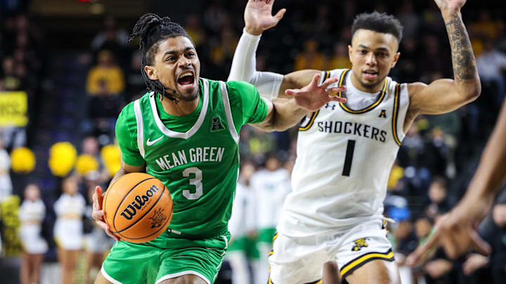 Jan 29, 2025; Wichita, Kansas, USA; North Texas Mean Green guard Jasper Floyd (3) drives to the basket around Wichita State Shockers guard Xavier Bell (1) during the first halfat Charles Koch Arena. Mandatory Credit: William Purnell-Imagn Images Jan 29, 2025; Wichita, Kansas, USA; North Texas Mean Green guard Jasper Floyd (3) drives to the basket around Wichita State Shockers guard Xavier Bell (1) during the first halfat Charles Koch Arena. Mandatory Credit: William Purnell-Imagn Images