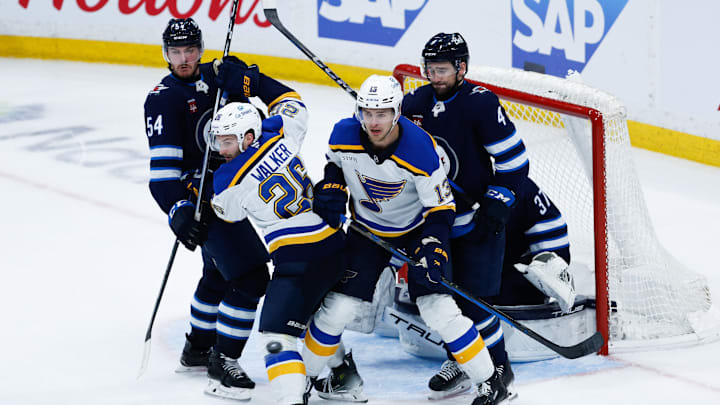 Apr 30, 2025; Winnipeg, Manitoba, CAN; St. Louis Blues forward Nathan Walker (26) and St. Louis Blues forward Alexey Toropchenko (13) jostle for position with Winnipeg Jets defenseman Dylan Samberg (54) and Winnipeg Jets defenseman Neal Pionk (4) during the third period in game five of the first round of the 2025 Stanley Cup Playoffs at Canada Life Centre. Mandatory Credit: Terrence Lee-Imagn Images