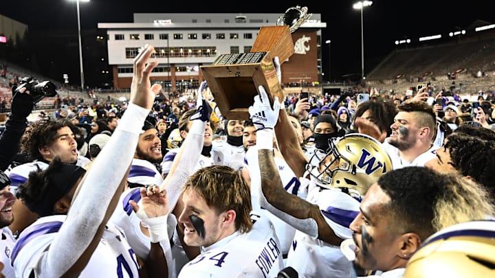 Huskies players hold up the Apple Cup Trophy in 2022.
