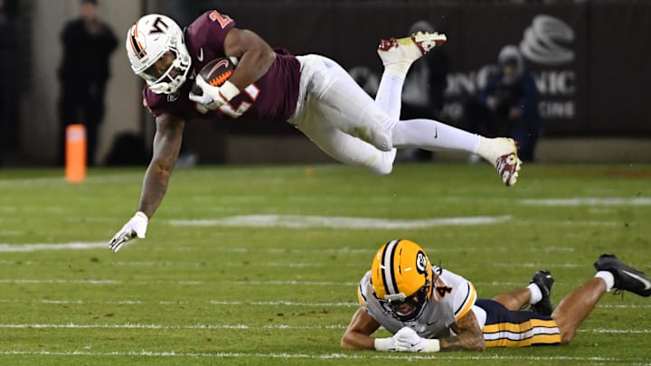Oct 24, 2025; Blacksburg, Virginia, USA;  Virginia Tech Hokies running back Tyler Mason (23) goes airborne after a hit by California Golden Bears defensive back Brent Austin (4) at Lane Stadium. Mandatory Credit: Brian Bishop-Imagn Images