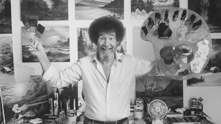 Bob Ross in his studio surrounded by his landscape paintings.