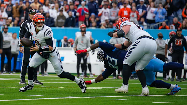 Cincinnati Bengals quarterback Joe Burrow (9) eludes a sack attempt by Tennessee Titans defensive tackle T'Vondre Sweat (93) during the first quarter at Nissan Stadium in Nashville, Tenn., Sunday, Dec. 15, 2024.