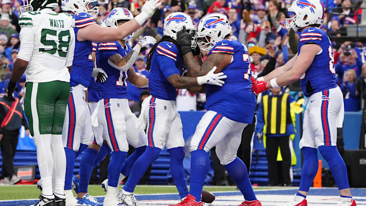 Buffalo Bills offensive tackle Dion Dawkins congratulates running back James Cook for scoring a touchdown.