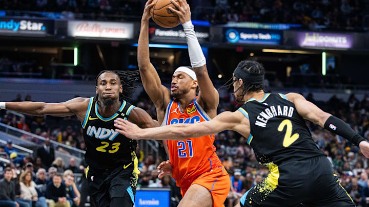 Apr 5, 2024; Indianapolis, Indiana, USA; Oklahoma City Thunder guard Aaron Wiggins (21) shoots the ball while Indiana Pacers forward Aaron Nesmith (23) and guard Andrew Nembhard (2)  defend in the second half at Gainbridge Fieldhouse. Mandatory Credit: Trevor Ruszkowski-Imagn Images