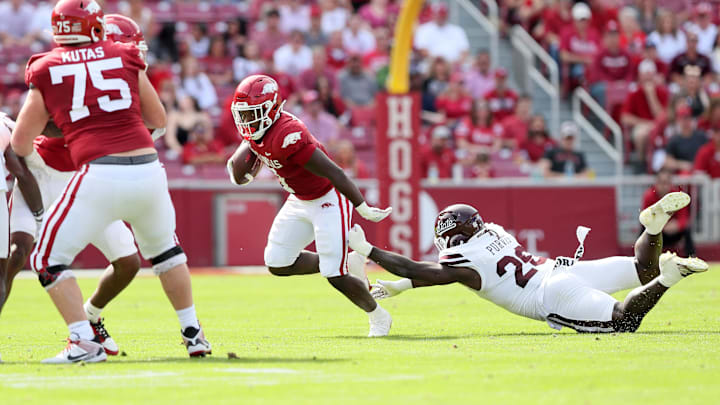 Oct 21, 2023; Fayetteville, Arkansas, USA; Arkansas Razorbacks running back Rashod Dubinion (7) runs the ball against Mississippi State Bulldogs linebacker J.P. Purvis (26) at Donald W. Reynolds Razorback Stadium. Mandatory Credit: Nelson Chenault-Imagn Images