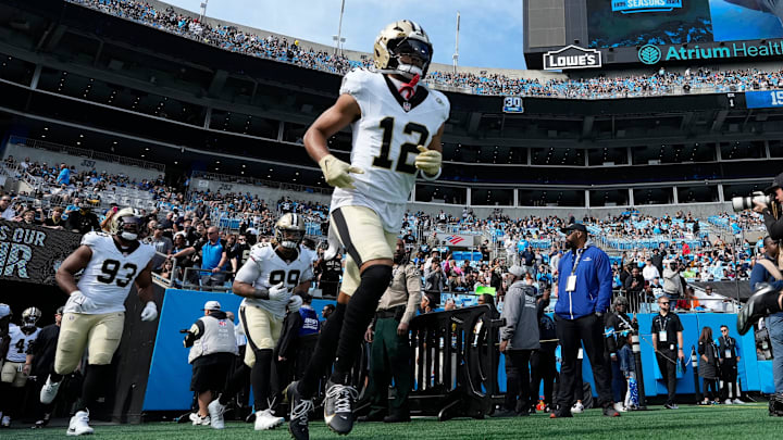 Nov 3, 2024; Charlotte, North Carolina, USA; New Orleans Saints wide receiver Chris Olave (12) runs on to the field before the game at Bank of America Stadium. Mandatory Credit: Bob Donnan-Imagn Images
