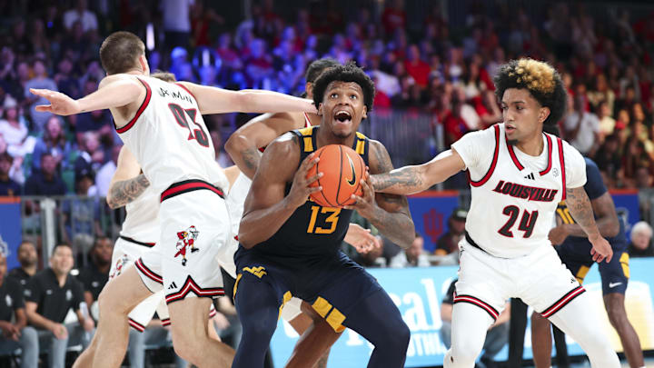 Nov 28, 2024; Paradise Island, Bahamas, BHS; West Virginia Mountaineers forward Amani Hansberry (13) looks to shoot as Louisville Cardinals forward Noah Waterman (93) and Louisville Cardinals guard Chucky Hepburn (24) defend during the second half at Imperial Arena at the Atlantis resort.  Mandatory Credit: Kevin Jairaj-Imagn Images