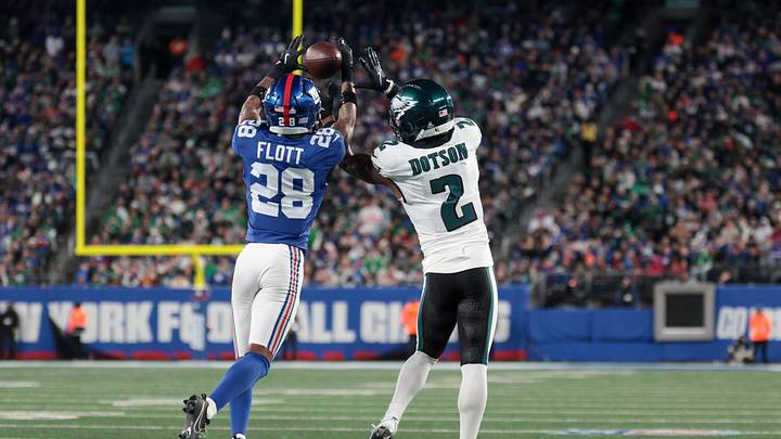 Oct 9, 2025; East Rutherford, New Jersey, USA; New York Giants cornerback Cor'Dale Flott (28) intercepts the pass intended for Philadelphia Eagles wide receiver Jahan Dotson (2) during the fourth quarter of the game at MetLife Stadium. Mandatory Credit: Vincent Carchietta-Imagn Images
