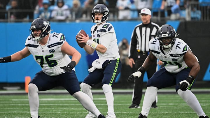 Dec 28, 2025; Charlotte, North Carolina, USA; Seattle Seahawks quarterback Sam Darnold (14) looks to throw a pass as guards Grey Zabel (76) and Josh Jones (74) block against the Carolina Panthers during the second quarter at Bank of America Stadium. Mandatory Credit: Bob Donnan-Imagn Images